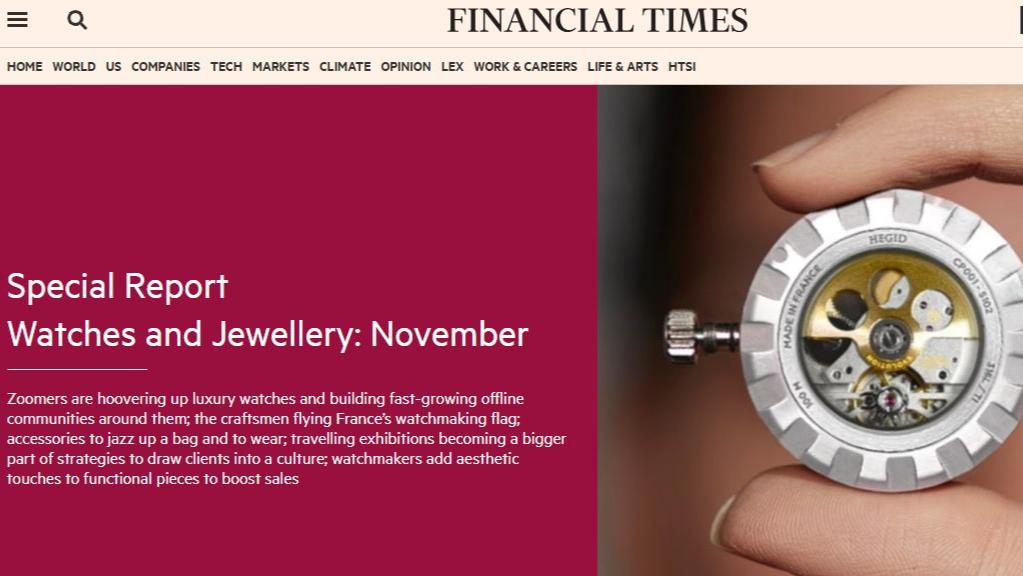 This Image shows a Clipping taken from the Financial Times Watches and Jewellery Report in November 2024. he image is Pink and white and has an inset image of a hand holding the internal mechanism from a wrist watch