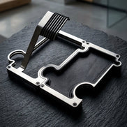 A silver metal watch stand with a black texture , resting on a dark slate surface in a modern interior setting.