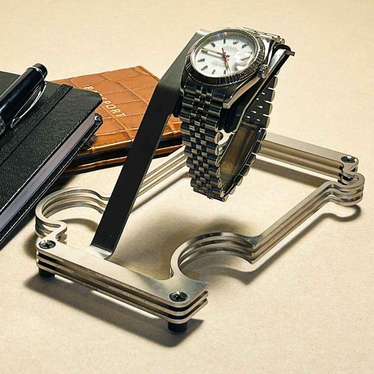 Puzzle Stand wit a rolex . there is a passport and notepad in the background