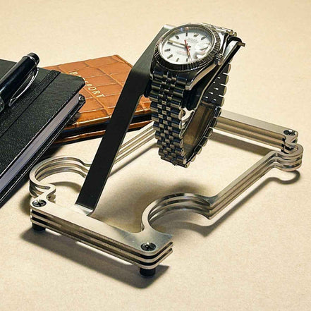 Puzzle Stand wit a rolex . there is a passport and notepad in the background
