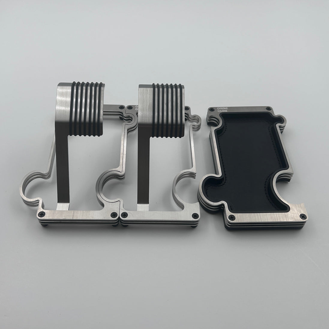 2 puzzle shaped watch stands interlinked and a separate puzzle shaped vanity tray beside them on a white backround