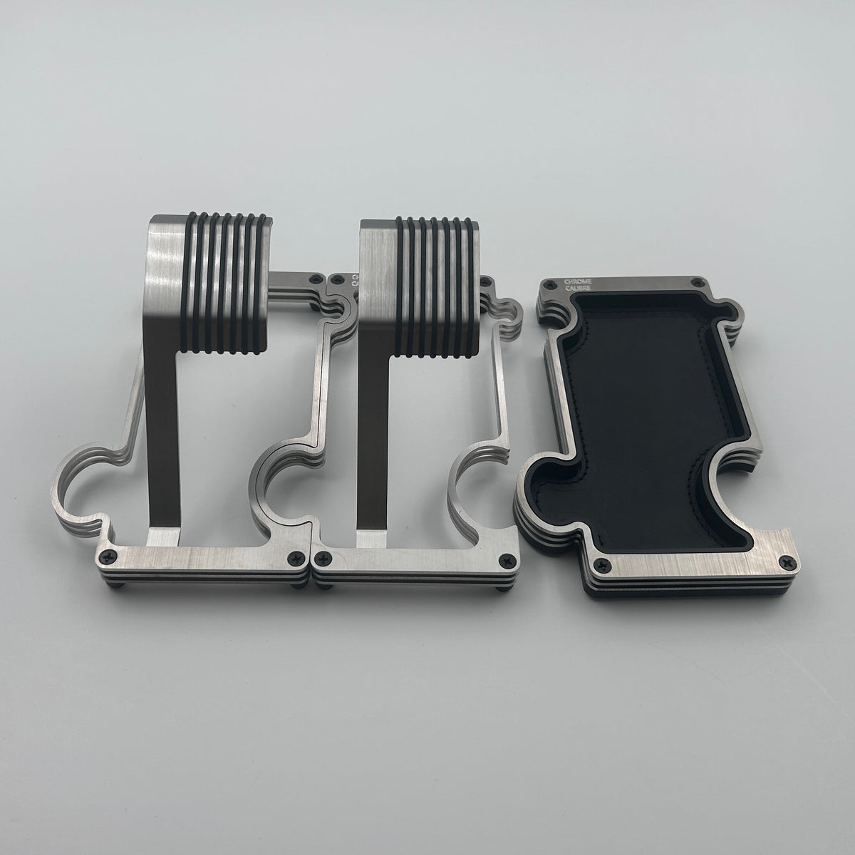 2 puzzle shaped watch stands interlinked and a separate puzzle shaped vanity tray beside them on a white backround