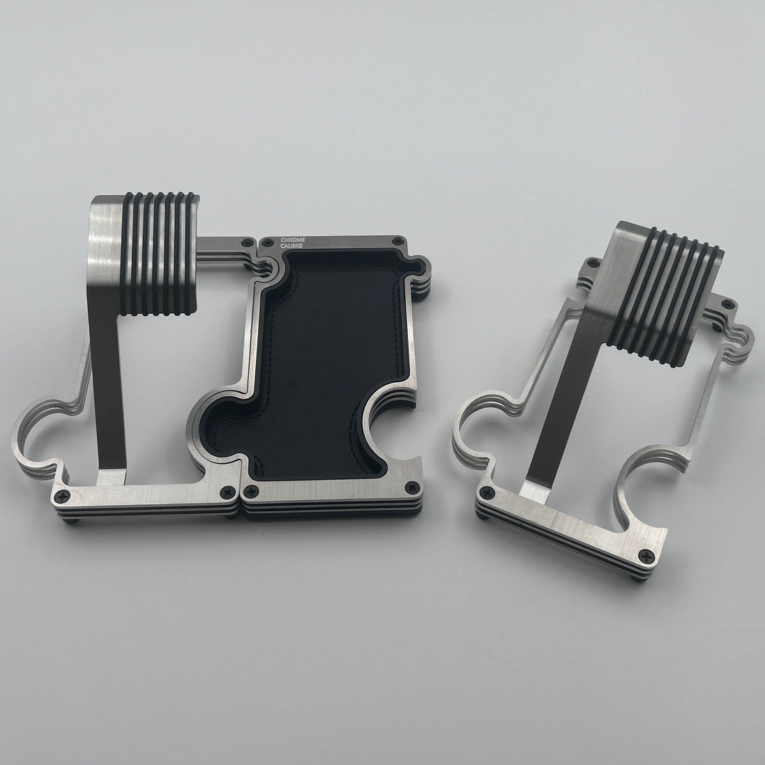 Two metallic objects on a light gray surface