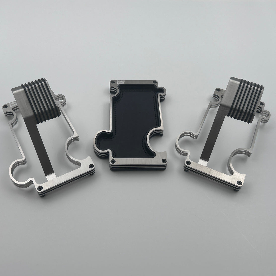 2 puzzle watch stands and 1 vanity tray in brushed steel on white background