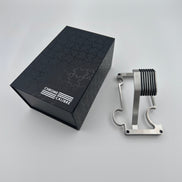 Metallic watch stand next to a black box with 'Chrome Calibre' branding on a light gray background