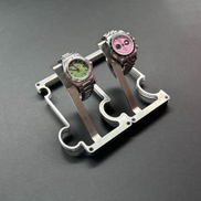 Two watches on a stand against a dark background