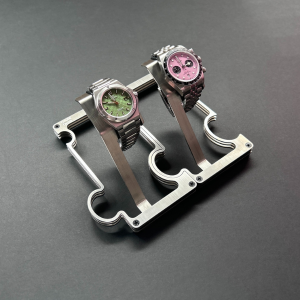 Two watches on a stand against a dark background