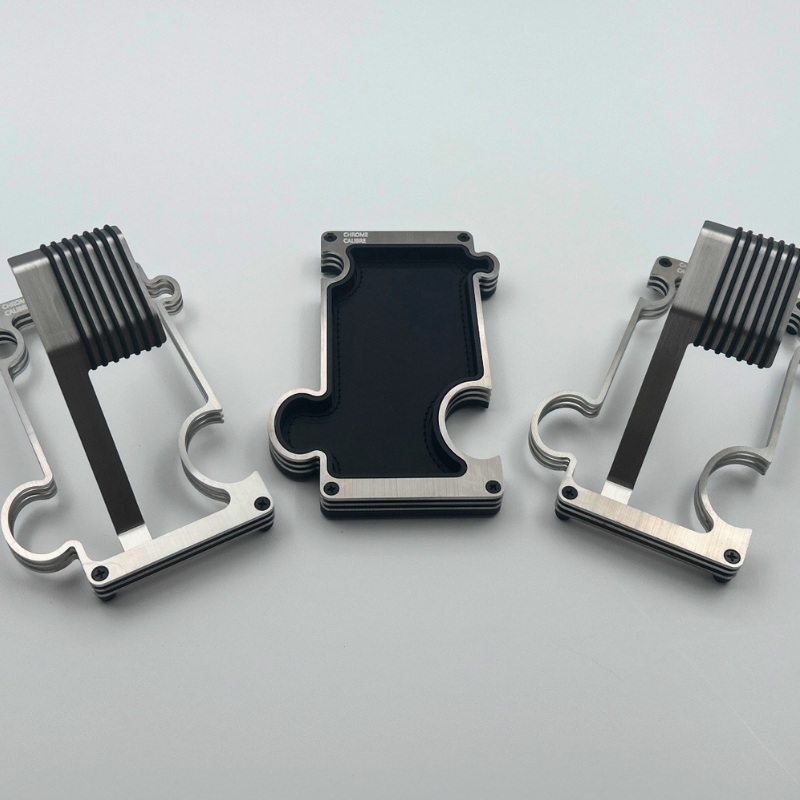 Three metallic watch stands and vanity tray on a light gray background