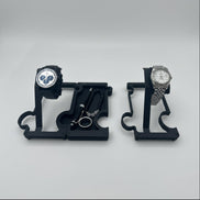 Black watch stands and vanity tray with watches resting on stands and pen, bracelet and ring resting in vanity tray