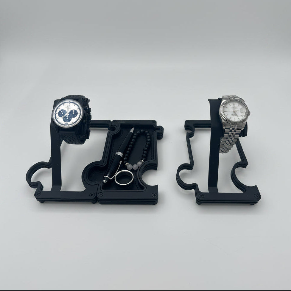 Black watch stands and vanity tray with watches resting on stands and pen, bracelet and ring resting in vanity tray