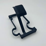 Black layered metal watch stand on white background styled like a jigsaw puzzle piece