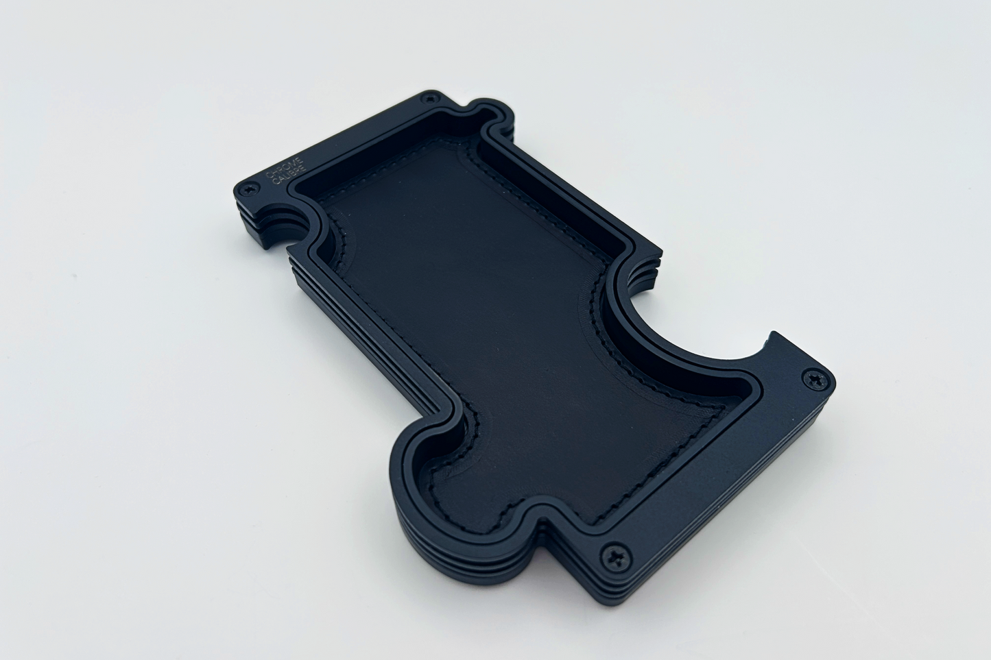 Black metal layer vanity tray with black leather inlay. shaped like a jigsaw puzzle piece