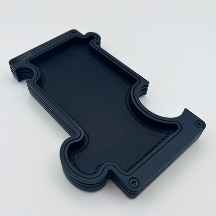 Black metal layer vanity tray with black leather inlay. shaped like a jigsaw puzzle piece
