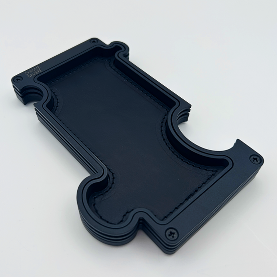 Black metal layer vanity tray with black leather inlay. shaped like a jigsaw puzzle piece