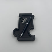 Black vanity tray with pen and cufflinks on white background