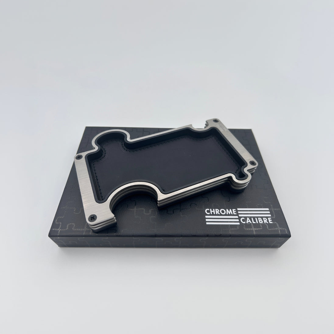 Metallic vanity tray on a black box with 'Chrome Calibre' branding