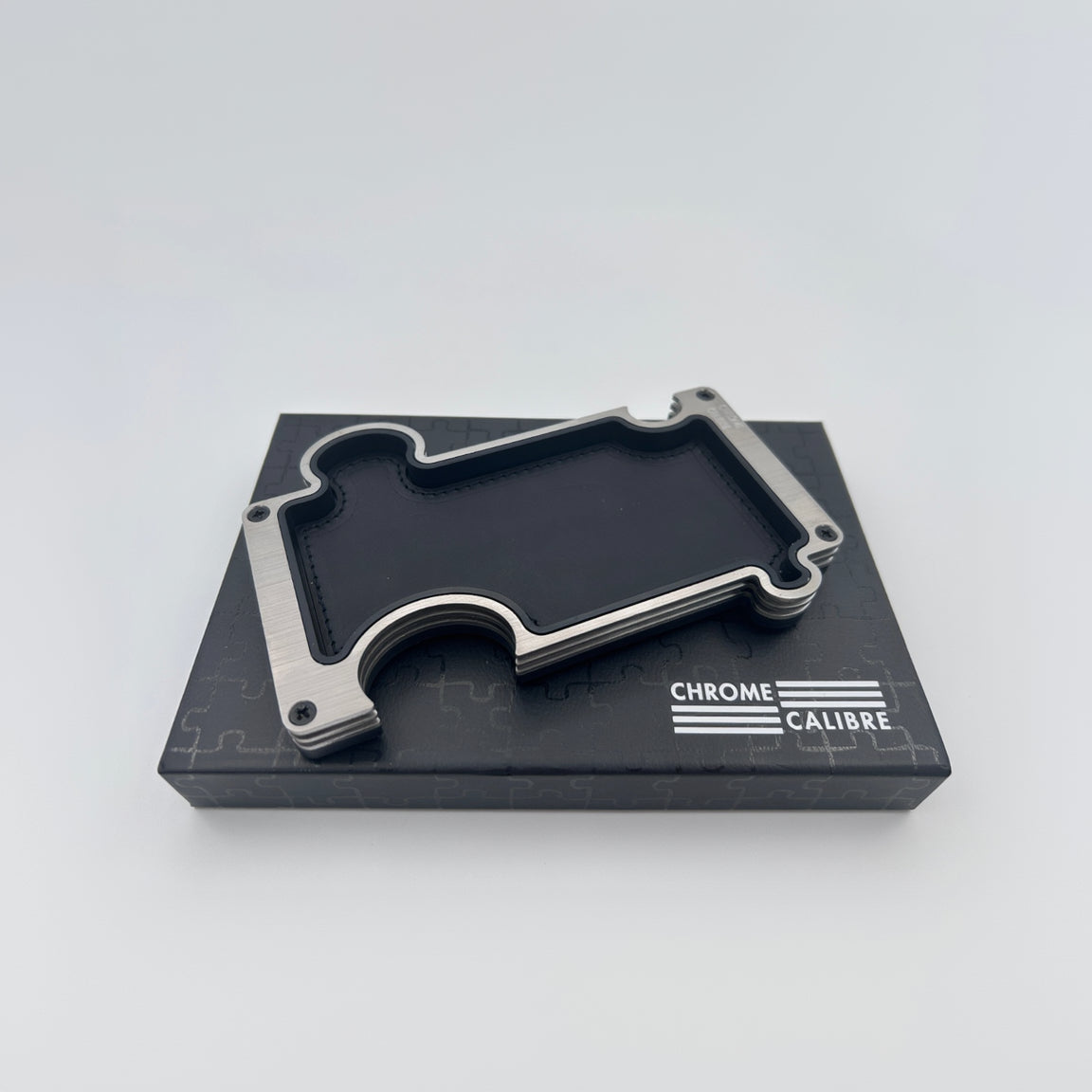 Metallic vanity tray on a black box with 'Chrome Calibre' branding