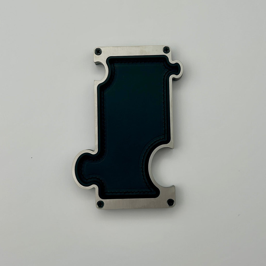 Black and silver metal piece on a gray background
