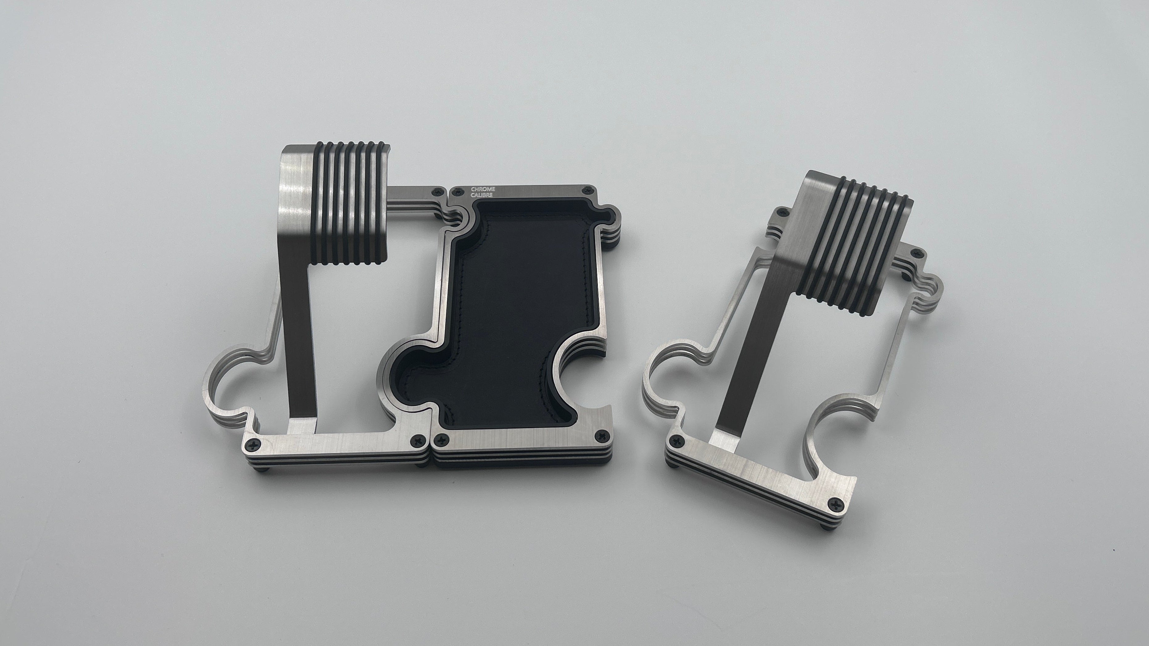 One watch stand connected to a vanity tray and a single stand on its own brushed steel on white background