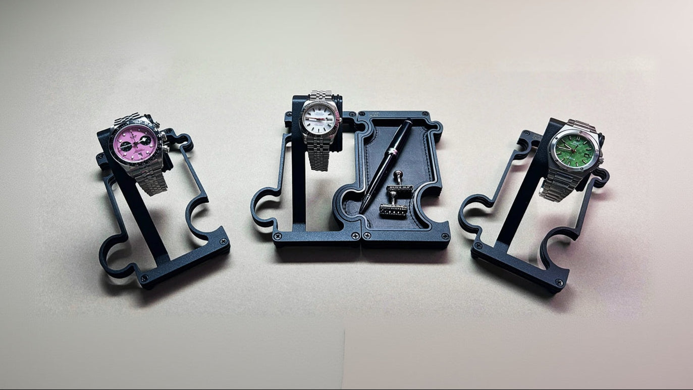Three watch stands with watches on a light gray background