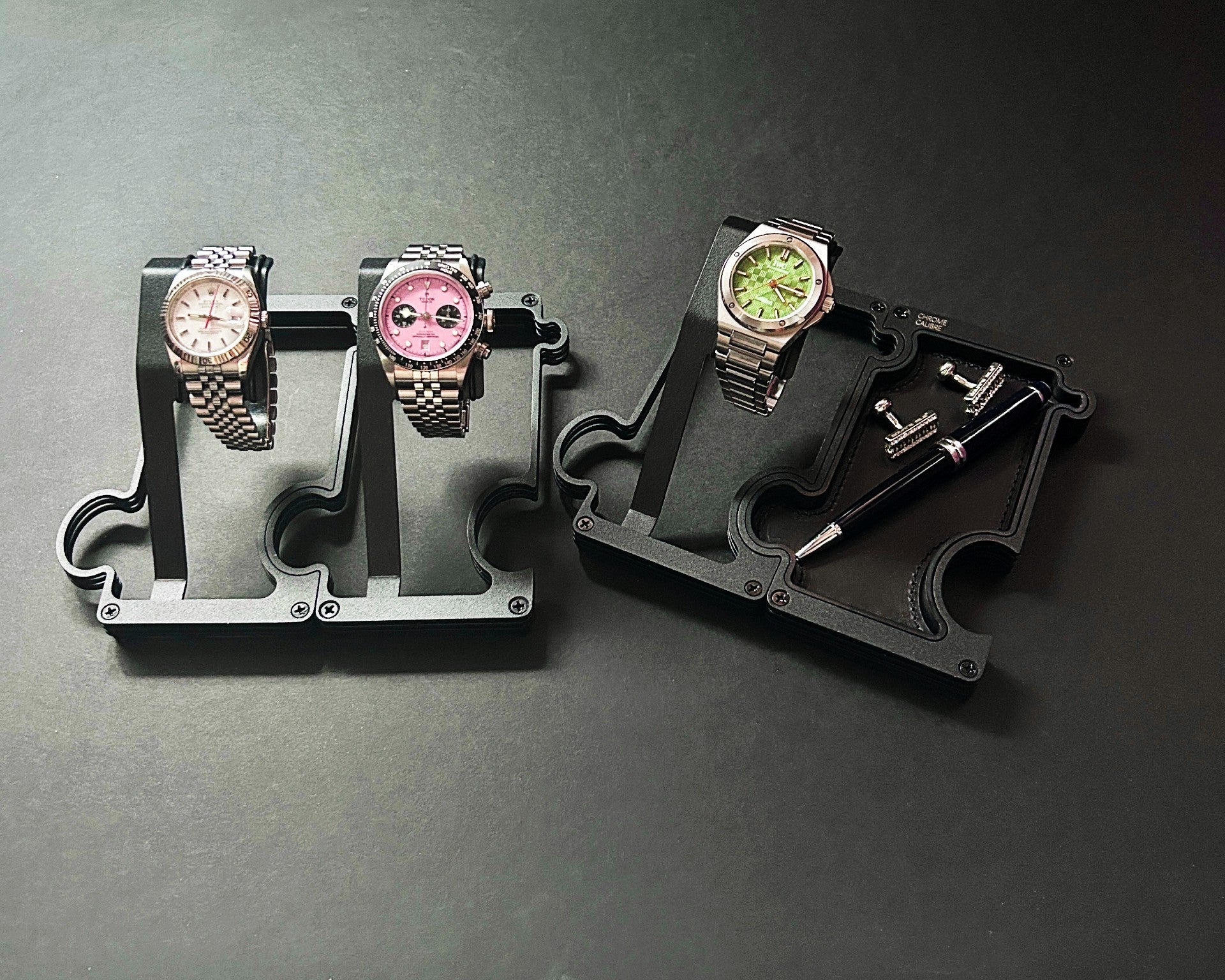 Three watch stands with watches on a dark gray background