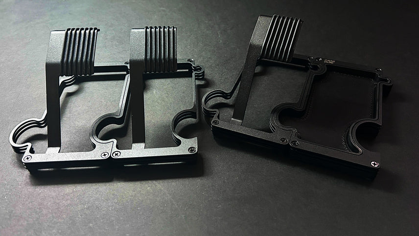 Three black metal watch stands and one vanity tray on a dark gray background