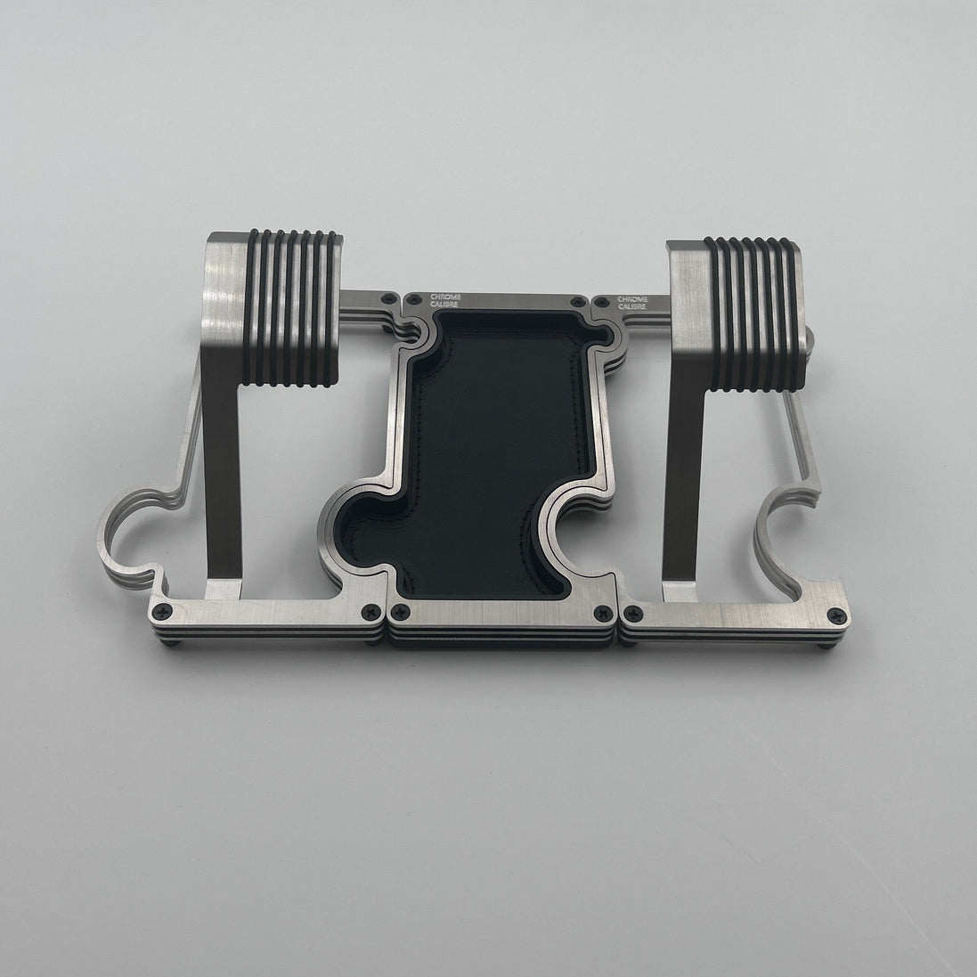 2 metal watch stands with a vanity tray between them in brushed steel with a white background