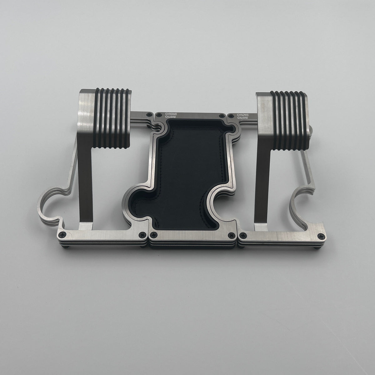 2 metal watch stands with a vanity tray between them in brushed steel with a white background